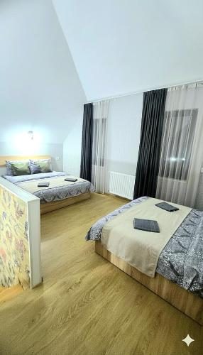 two beds in a room with wooden floors at Weekend Borjomi in Borjomi
