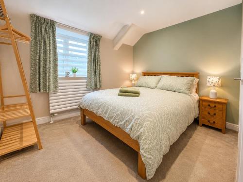 a bedroom with a bed and a ladder and a window at Appletree Cottage in Wells