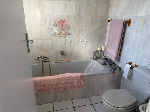 a bathroom with a bath tub and a toilet at Sweet Willa Bed and Breakfast in Roodepoort
