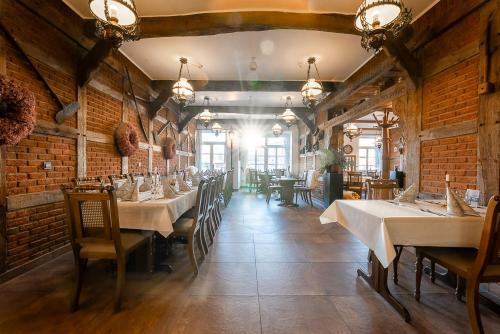 a dining room with tables and chairs in a building at Hotel Pelikan in Papenburg