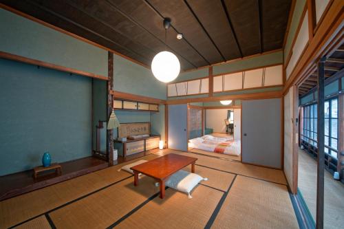a bedroom with a bed and a table in a room at ISEZI Historic Machiya in Shibata