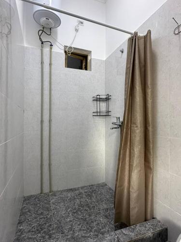 a shower with a shower curtain in a bathroom at Dream Guest House in Bosteri