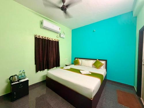 a bedroom with a bed with a blue wall at De Quite Villa in Pondicherry