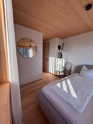 a bedroom with a bed with a wooden ceiling at Panoramazimmer im Bregenzerwald in Schwarzenberg