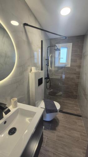 a bathroom with a sink and a shower and a toilet at Wide shore Apt in Kamári