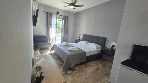 a bedroom with a bed and a window and a television at Wide shore Apt in Kamári