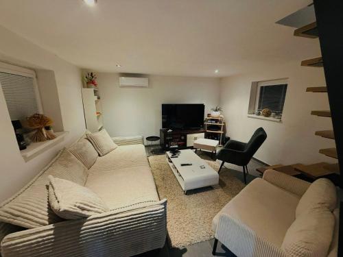 a living room with a couch and a tv at Chalúpka pod hviezdami in Uličské Krivé