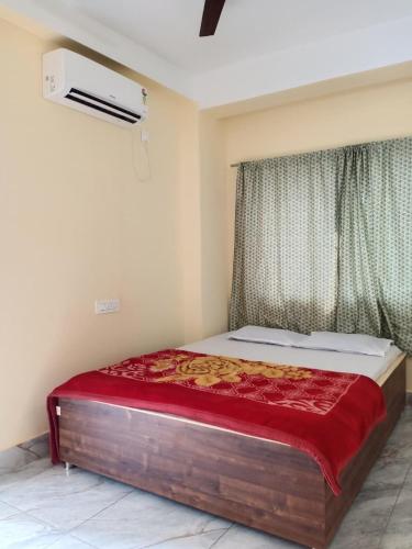 a bed sitting in a room with a window at Shivmandir Homestay in Siliguri