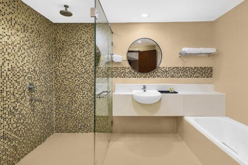a bathroom with a sink and a shower with a mirror at Sunday Residence Inn Cherating in Cherating