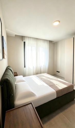 a large white bed in a room with a window at Casa Nanà - Sottomarina in Chioggia