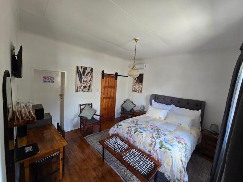 a bedroom with a bed and a table in it at Eagles Accommodation in Colesberg