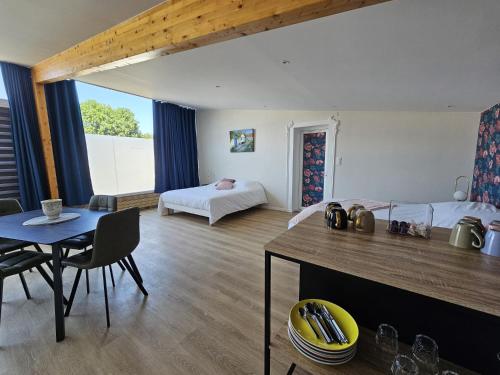 a room with a bed and a dining table and a bedroom at Les Logis des Treize-Vents à 15 minutes du Puy duFou in Treize-Vents