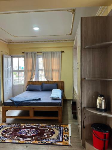 a bedroom with a bed and a window at Lakecity Apartment in Pokhara