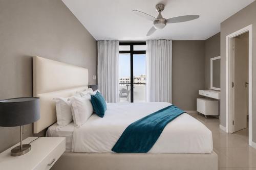 a bedroom with a large bed with a ceiling fan at Modern Ocean View Apartment in Cape Town