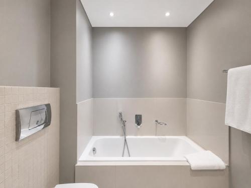 a bathroom with a bath tub and a toilet at Modern Ocean View Apartment in Cape Town