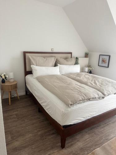 a bedroom with a large bed with white sheets at Haus David in Erfurt