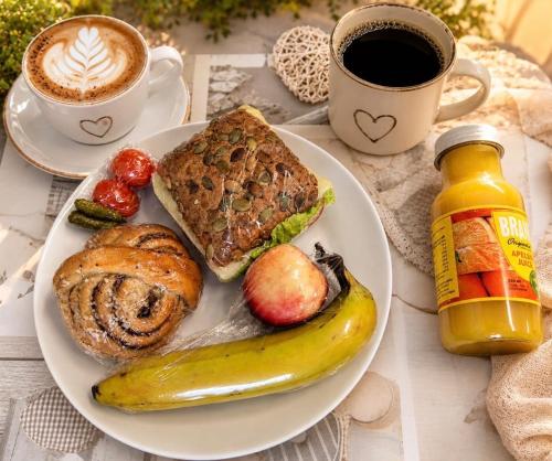a plate of breakfast food with a banana and a cup of coffee at Gränna View in Gränna