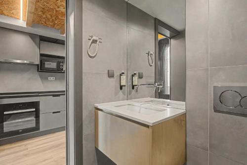 a kitchen with a sink and a stove at Apartamento do Laço in Aveiro
