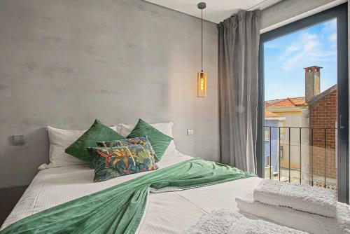a bedroom with a bed with pillows and a window at Apartamento do Laço in Aveiro