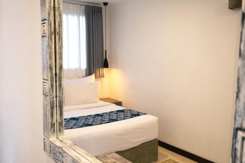 a bedroom with a mirror next to a bed at Alami Apartment Seminyak in Seminyak