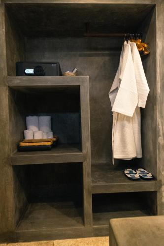 a shelf in a bathroom with towels on it at Alami Apartment Seminyak in Seminyak