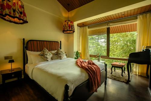 a bedroom with a bed and a large window at MONKEY RESORT in McLeod Ganj