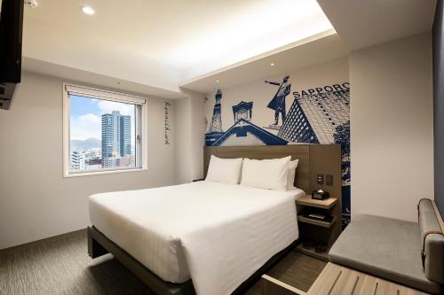 a bedroom with a large white bed and a window at KOKO HOTEL Sapporo Susukino 2ⁿᵈ in Sapporo