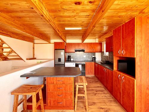 a kitchen with wooden cabinets and a large island at Brückendorf 11 Self-catering townhouse in Swakopmund
