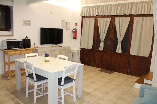 a living room with a white table and chairs and a tv at MaraSal in Pozzallo