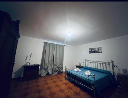 a bedroom with a bed with a blue bedspread at Agriturismo Relais Kloe in Castel Boglione