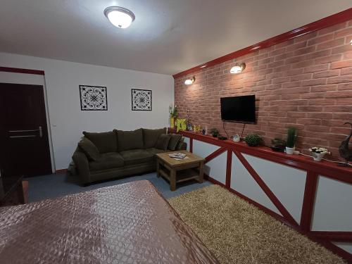 a living room with a couch and a brick wall at Izba v centre in Bardejov