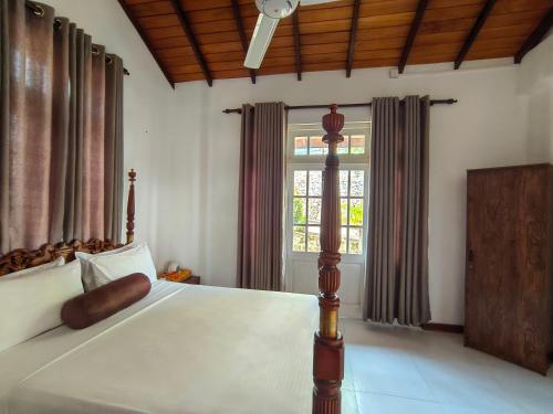 a bedroom with a bed and a large window at Sky Lodge in Kandy