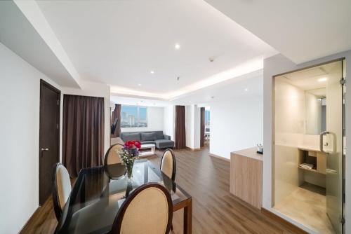 a living room with a glass table and chairs at ASTON Pluit Hotel & Residence in Jakarta