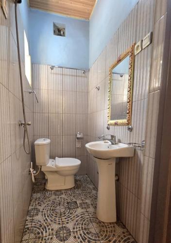 a bathroom with a toilet and a sink at Akagera Sunset House in Kabarondo