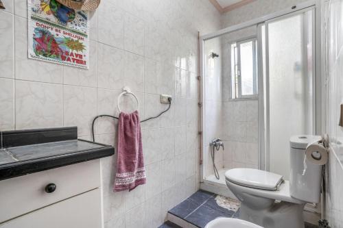 a white bathroom with a toilet and a sink at Casa Pantha in Vélez-Málaga