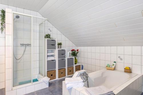a white bathroom with a tub and a shower at Fewowe Ferienwohnung Wenden in Wenden