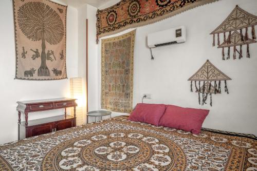 a bedroom with a bed with a red pillow and a table at Casa Pantha in Vélez-Málaga