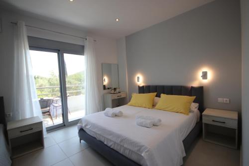 a bedroom with a large bed with towels on it at Avli Rooms in Himare