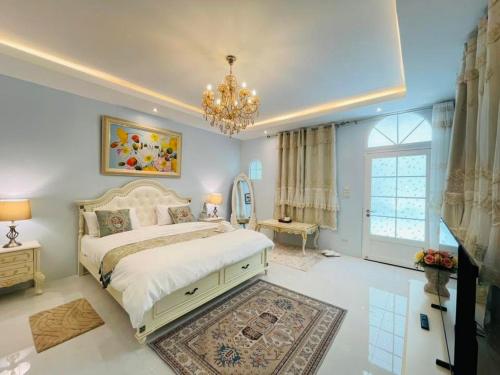 a bedroom with a large bed and a chandelier at ปางสูงเฮาส์ pangsunghouse in Ban Pang Bo Hu Bon
