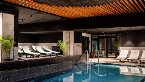 a hotel swimming pool with lounge chairs next to it at Jacob Sea Life Nahariya in Nahariyya
