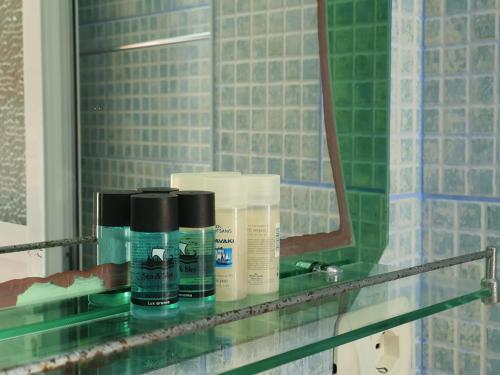 a glass shelf in a bathroom with products on it at Ionian Balcony in Himare