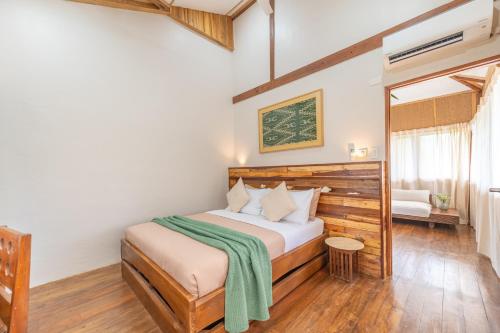 a bedroom with a bed with a green blanket on it at Camanolo Residence in General Luna