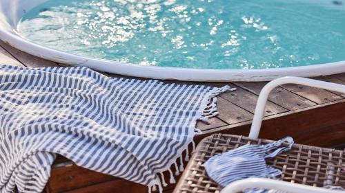 a group of chairs on a deck next to a pool at Jacob Shenkin Hotel in Tel Aviv