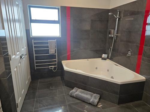 a bathroom with a bath tub and a window at De Vine Martinborough #14a in Martinborough