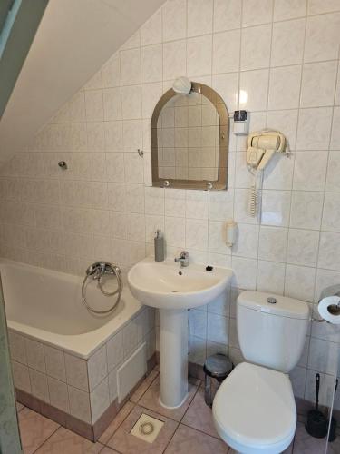 a bathroom with a sink and a toilet and a tub at Pensjonat Pałacyk in Łańcut