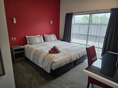 a bedroom with a bed with a teddy bear on it at De Vine Martinborough #14a in Martinborough