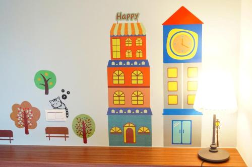 a wall mural of a building with a clock at Mulin B&B in Hengchun