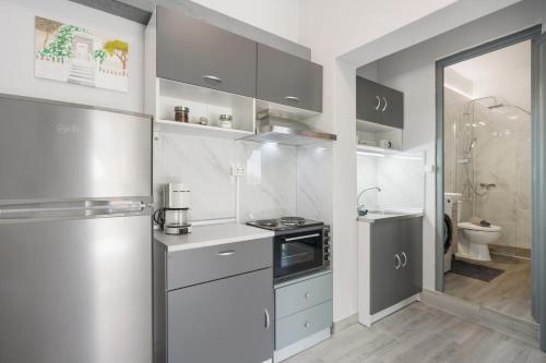 a white kitchen with a refrigerator and a sink at 30Roses House in Sálakos