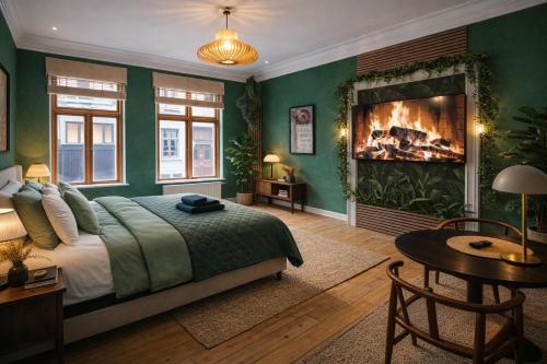 a bedroom with green walls and a bed with a fireplace at Danmarksgade Green Suites in Aalborg