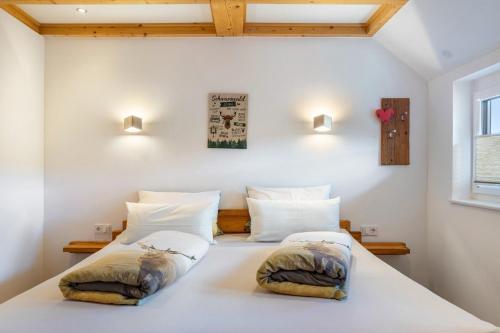 two beds in a room with white walls at Ferienwohnungen Schwarzwaldtraum in Unterkirnach